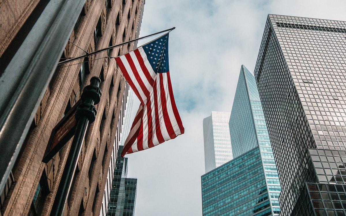 Stylized US map with client-location pins, or office exterior with flag