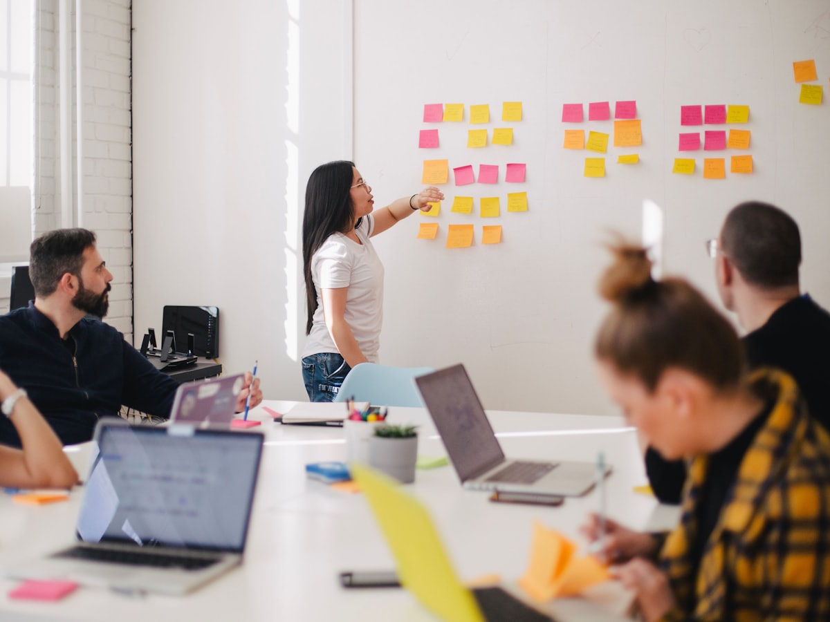 Whiteboard covered in user-flow sketches, sticky notes and a tablet with a prototype